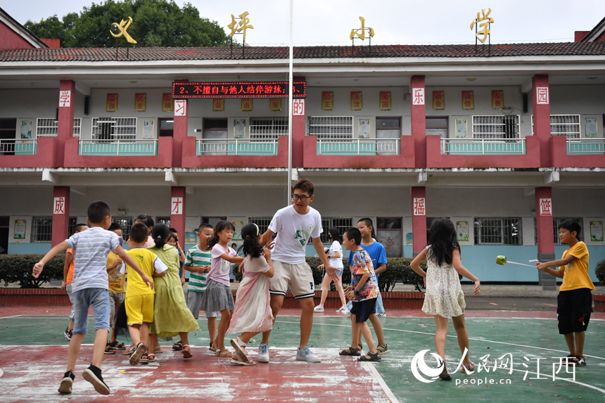 在學(xué)校操場(chǎng)上，支教學(xué)生和留守兒童們一起做游戲。 人民網(wǎng) 時(shí)雨攝