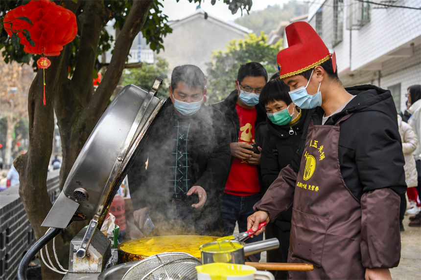 游客在山貨節(jié)上選購(gòu)農(nóng)家手工小吃。周亮攝