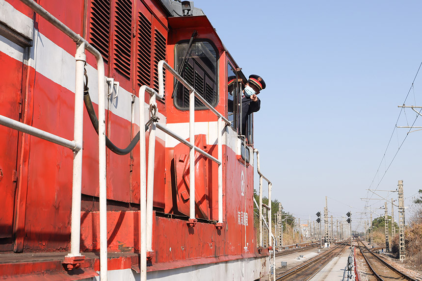 中國(guó)鐵路南昌局集團(tuán)有限公司鷹潭機(jī)務(wù)段調(diào)機(jī)司機(jī)開(kāi)門手比確認(rèn)調(diào)車信號(hào)，確保春耕物資專列運(yùn)輸安全。劉東攝