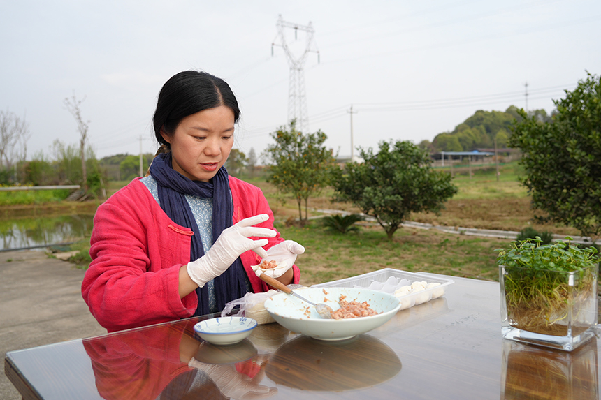 李宜玲正在小院里包餃子，招待客人。上高縣委宣傳部供圖