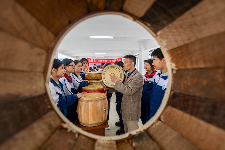 近日，江西省吉安市永新縣開(kāi)展技能大師進(jìn)校園活動(dòng)。當(dāng)?shù)刂乒募寄艽髱熢诮o孩子們傳授制鼓技藝。王惠民攝