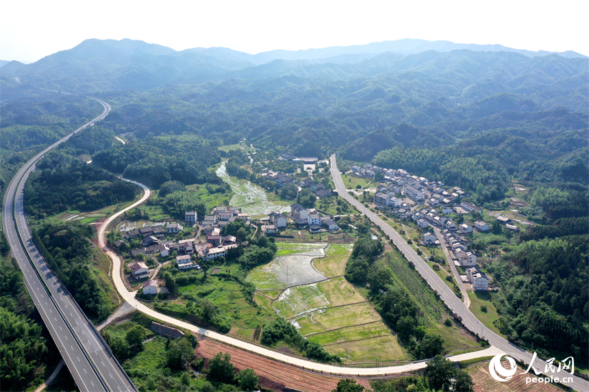 翻新后的民居點綴于青山間，撫吉高速公路蜿蜒而過。 人民網記者 時雨攝