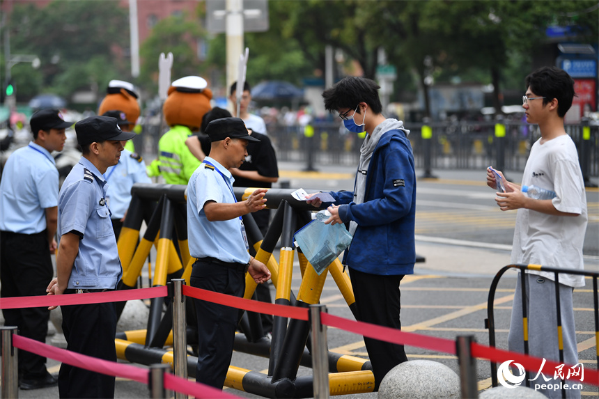 圖為考點工作人員正在查驗考生證件。 人民網(wǎng)記者 時雨攝