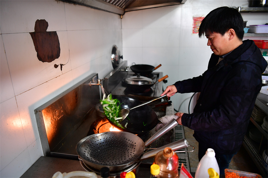 葉延海正在廚房炒菜。 人民網(wǎng)記者 時雨攝