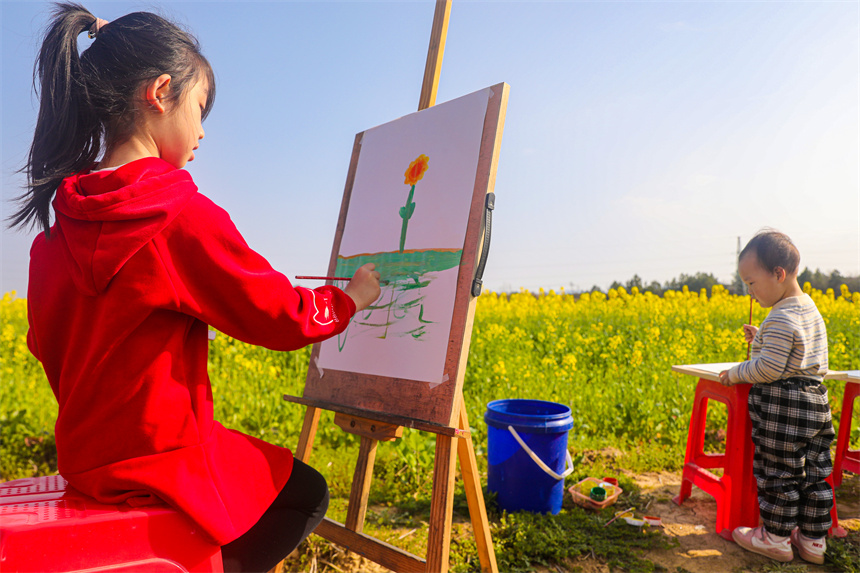 孩子們在油菜花地里作畫。李煜祖攝