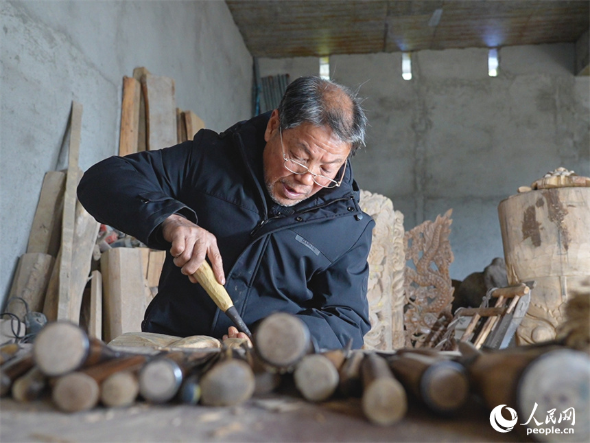 國家級非遺傳承人賴明德正在制作儺面具。人民網(wǎng) 孔文進攝