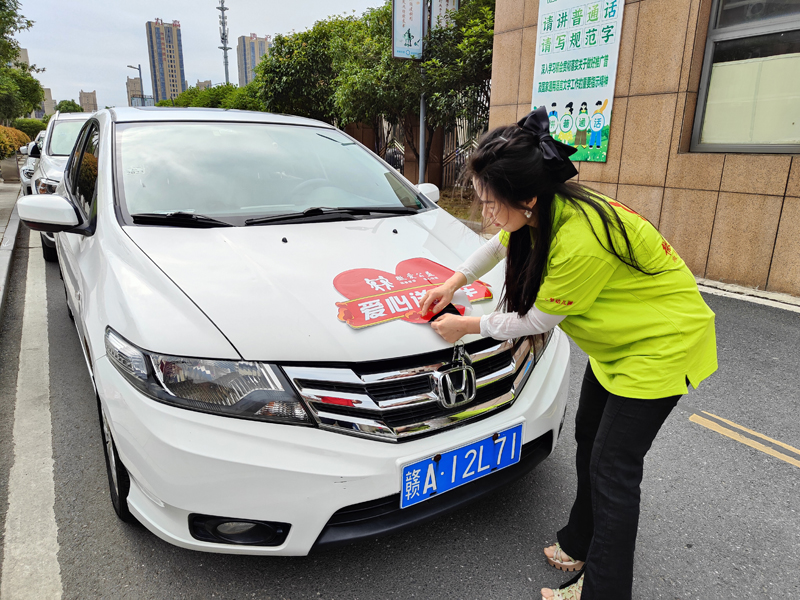 志愿者在車上貼好“愛心送考車標(biāo)識(shí)”。地方供圖