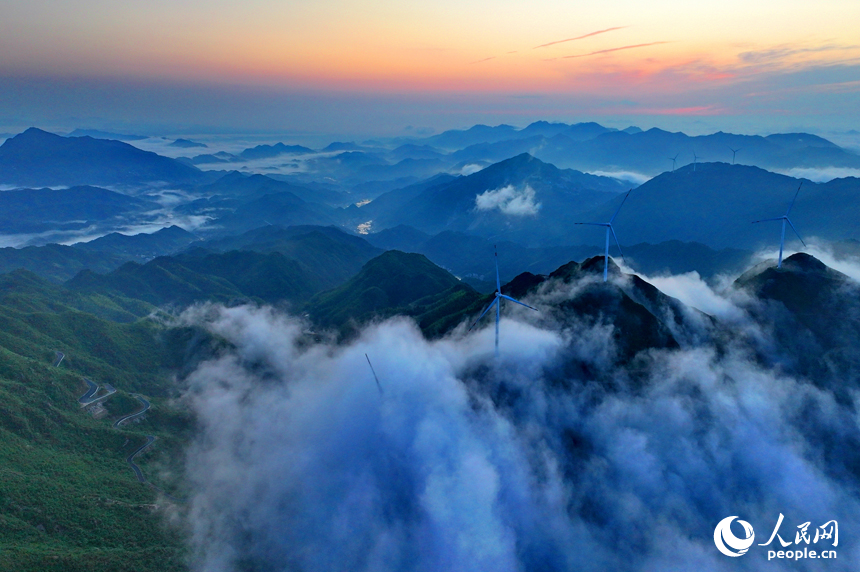 在吉安市遂川縣左溪鎮(zhèn)洋溪村俯瞰雙溪草山，數(shù)十臺風(fēng)力發(fā)電機(jī)迎風(fēng)旋轉(zhuǎn)，與朝霞、云海、青山交相輝映，風(fēng)景如畫。人民網(wǎng) 朱海鵬攝