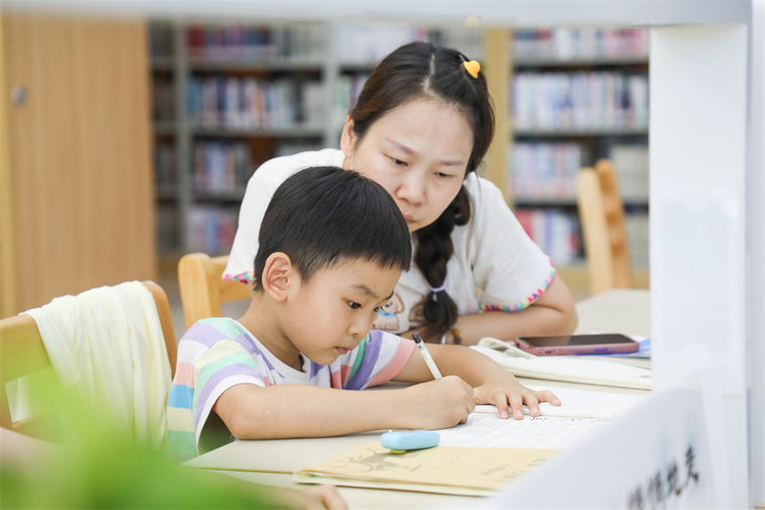 家長(zhǎng)帶著孩子在圖書館閱讀。彭亮攝