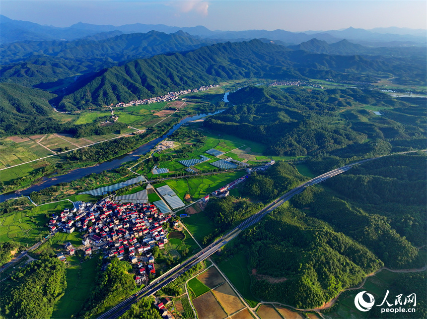 德興市張村鄉(xiāng)店前村一帶，農(nóng)房、田園、河流在巍峨群山的掩映下美如畫卷，風(fēng)景怡人。人民網(wǎng) 朱海鵬攝