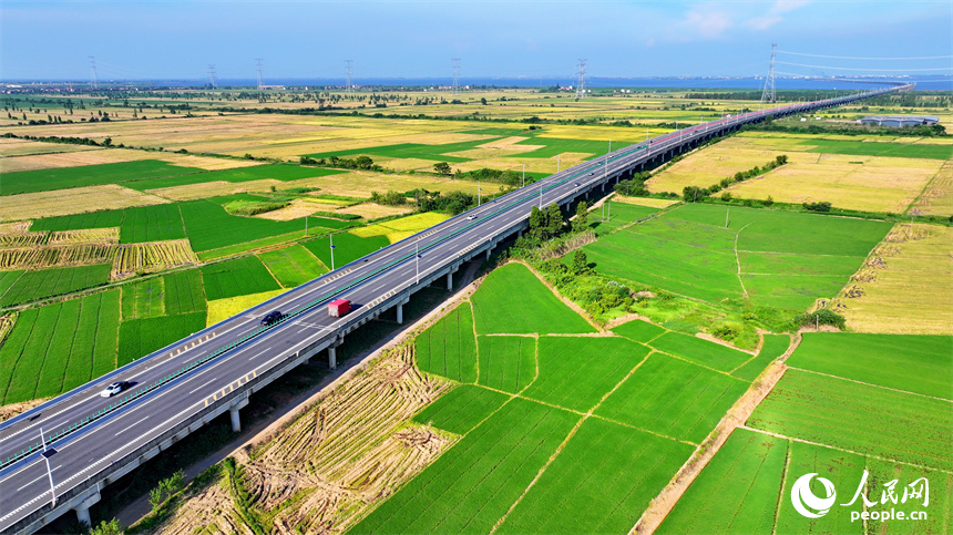 南昌市南昌縣涇口鄉(xiāng)，杭長高速公路上的車輛穿村而過，沿途田園廣袤、碧波萬頃，美景如畫。人民網(wǎng) 朱海鵬攝