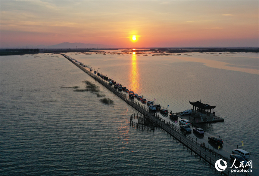 鄱陽(yáng)湖水位降低，永吳公路大湖池段“浮出”水面，游客們駕車“沖浪”。人民網(wǎng)記者 時(shí)雨攝