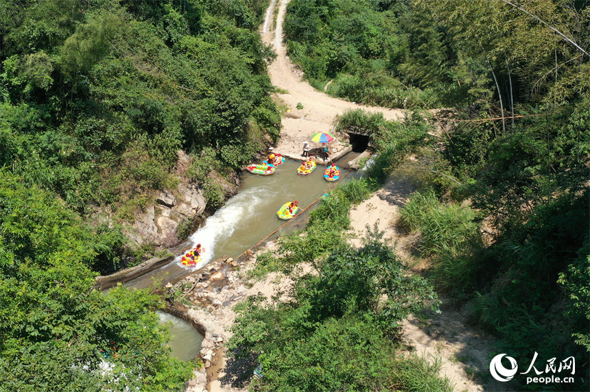 上高縣峽谷漂流水道上色彩斑斕，游客們在漂流艇上戲水消暑。人民網(wǎng)記者 時(shí)雨攝