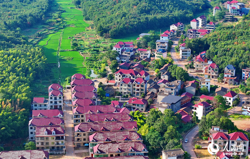 撫州市東鄉(xiāng)區(qū)孝崗鎮(zhèn)西源村的農(nóng)房與通村公路、連綿青山相互映襯，美不勝收。人民網(wǎng) 朱海鵬攝