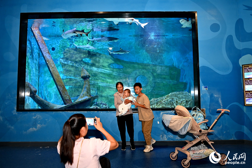 九江市湖口縣江豚灣的長江鄱陽湖水生生物保護(hù)基地，許多游客在水族館觀賞水生物。人民網(wǎng) 朱海鵬攝