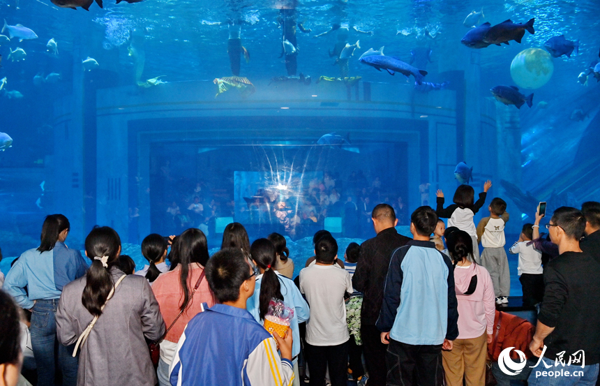 九江市湖口縣江豚灣的長江鄱陽湖水生生物保護基地，許多游客在水族館觀賞水生物。人民網(wǎng) 朱海鵬攝