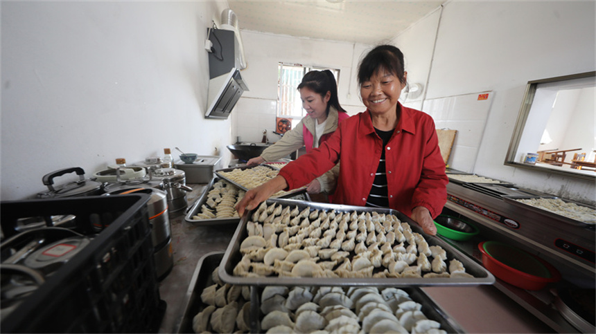 黨員干部和巾幗志愿者為留守老人們包餃子。饒方其攝